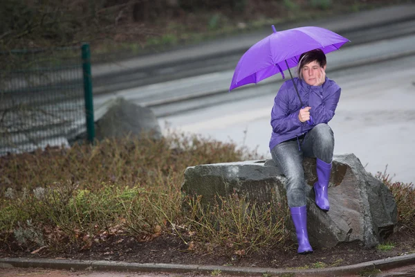 Impermeable mujer vestida esperando bajo la lluvia —  Fotos de Stock
