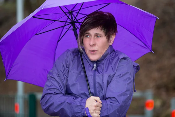 Mulher de pé na chuva e está congelando — Fotografia de Stock