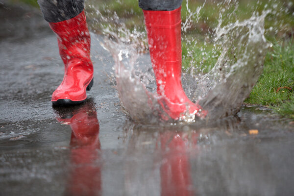 Rubber boot are jumping into a big puddle