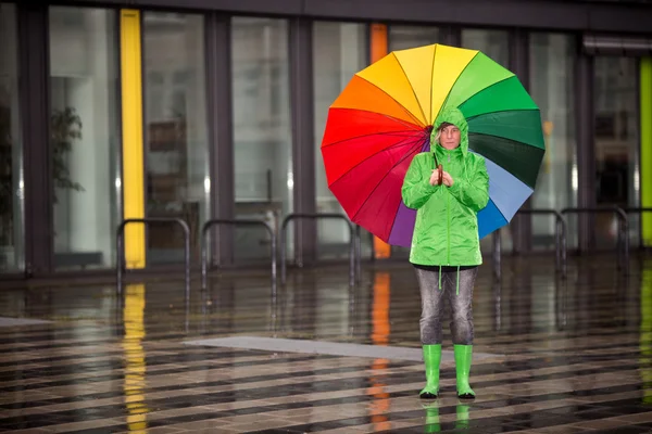 Mujer esperando bajo la lluvia con su paño de lluvia — Foto de Stock