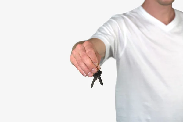 Ein Mann mit einem Schlüssel, isoliert auf einem grauen Hintergrund — Stockfoto