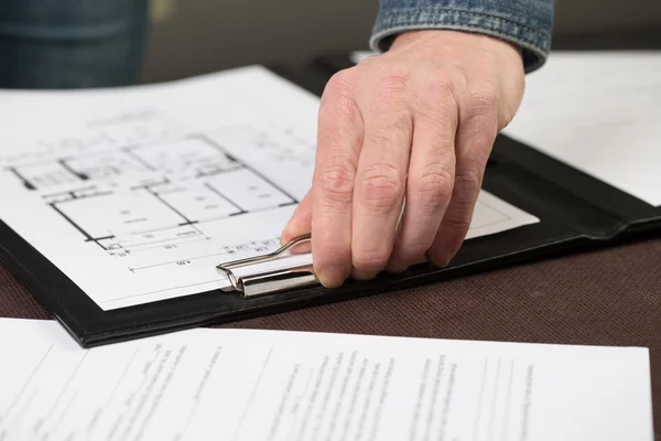 Some floorplans are clipped to a clipboard by an architect. — Stock Photo, Image