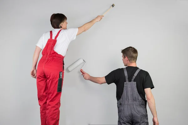 Trabalho em equipe de um casal estão pintando uma parede cinza — Fotografia de Stock