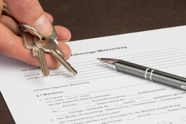 German rental agreement with house keys in one hand — Stock Photo, Image