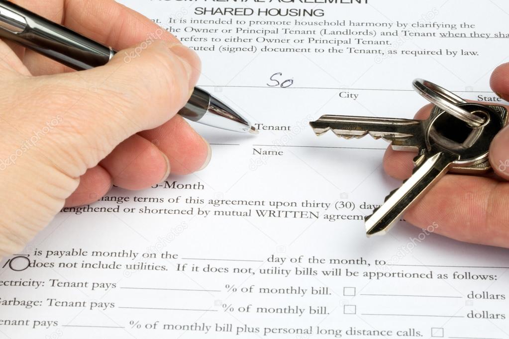 Filling out a room rental agreement with keys in hand