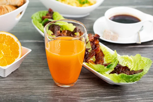 Glass of orange juice with a plate of bacon with salad and a cof — Stock Photo, Image