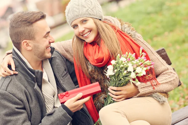 Romantische koppel met presenteert in park — Stockfoto