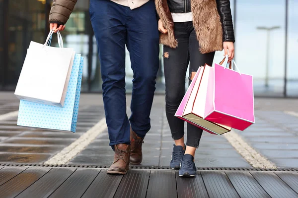 Sección media de la pareja con bolsas de compras — Foto de Stock