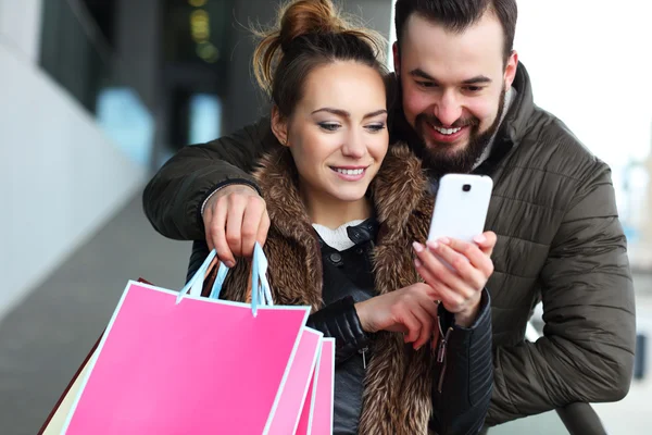 Paar kauft mit Smartphone in der Stadt ein — Stockfoto