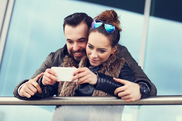 Pareja joven mensajes de texto en la ciudad — Foto de Stock