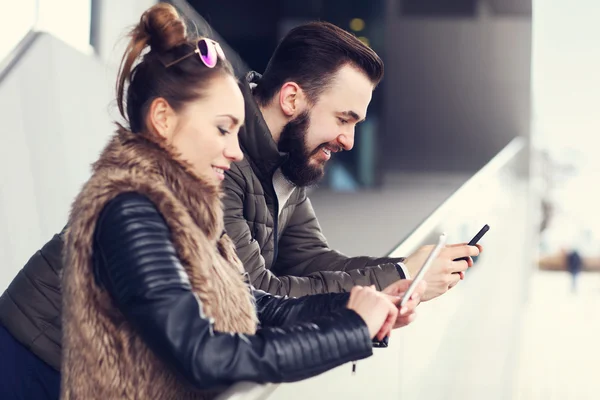 Jong (echt) paar texting in stad — Stockfoto