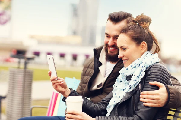 Pareja con bolsas de compras y smartphone —  Fotos de Stock