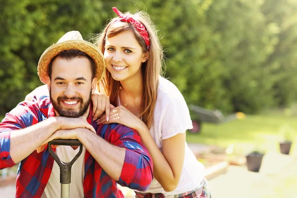 Jovem casal trabalhando no jardim — Fotografia de Stock