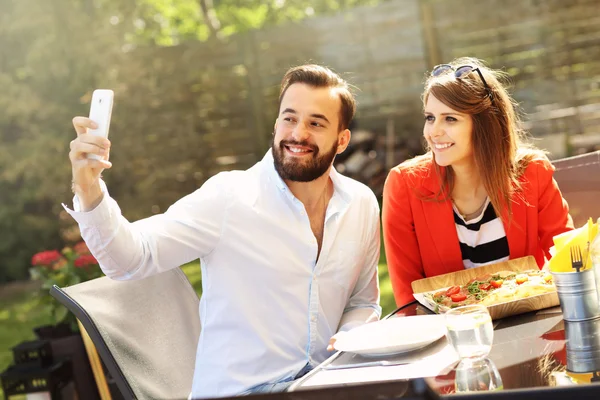 Para biorąc selfie w restauracji — Zdjęcie stockowe