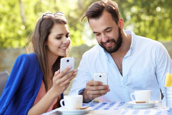 Casal usando smartphones no restaurante — Fotografia de Stock