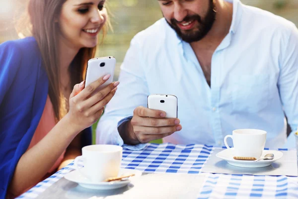 Пара, использующая смартфоны в ресторане — стоковое фото