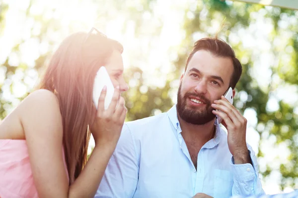 Pareja romántica usando teléfonos inteligentes — Foto de Stock