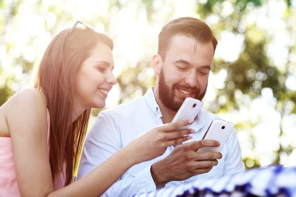 Romantyczna para za pomocą smartfonów — Zdjęcie stockowe