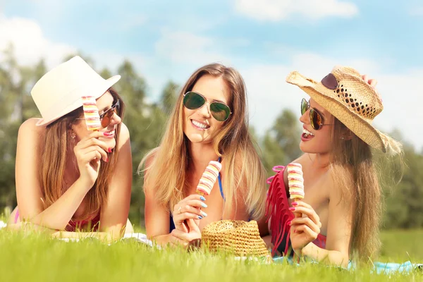 Mulheres felizes refrigerando com sorvete — Fotografia de Stock