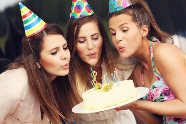 Vänner blåsa ljusen på tårtan — Stockfoto