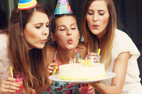 Grupo de amigos soprando velas no bolo — Fotografia de Stock