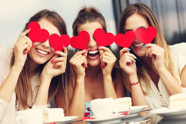 Freundinnen halten Herzen im Café — Stockfoto