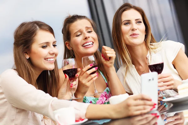 Grupp vänner chattar i café och använder smartphone — Stockfoto