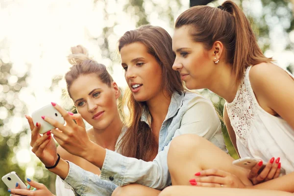 Flickvänner med smartphones — Stockfoto