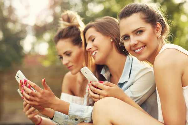 Feliz grupo de amigos con teléfonos inteligentes — Foto de Stock