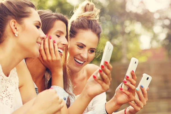 Happy group of friends with smartphones — Stock Photo, Image