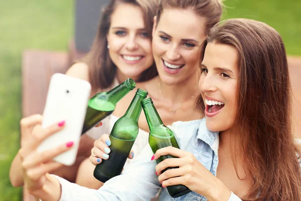 Amigos felizes bebendo cerveja ao ar livre — Fotografia de Stock