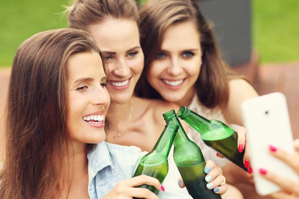 Venner som drikker øl og tar selfie – stockfoto