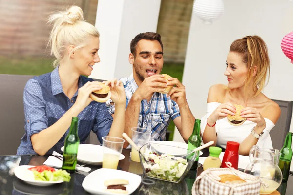 Grupp vänner äter hamburgare — Stockfoto