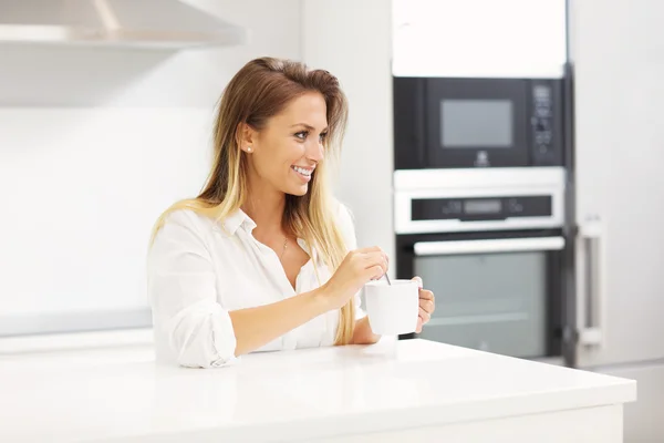 Mujer joven con café en la cocina — Foto de Stock