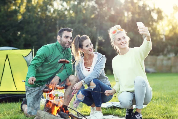 Vrienden kamperen in het bos en nemen selfie — Stockfoto