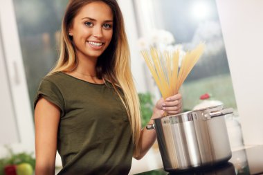 kadın mutfakta spagetti hazırlanıyor