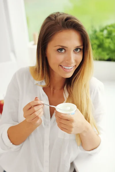 Jonge vrouw met yoghurt — Stockfoto