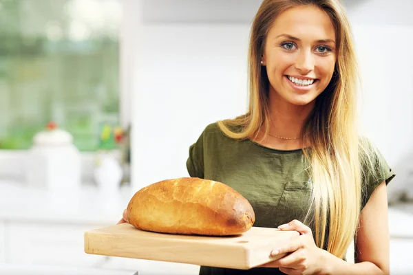 Vrouw met brood in de keuken — Stockfoto