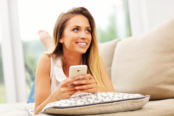 Frau auf Couch mit Smartphone — Stockfoto