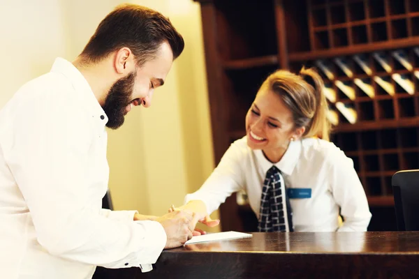 Hombre firma proyecto de ley en hotel — Foto de Stock