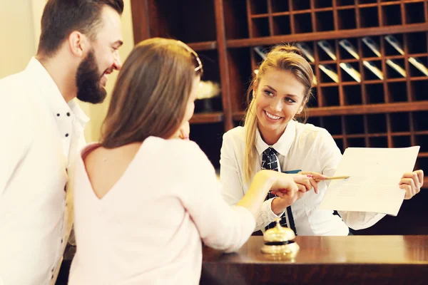 Couple and receptionist at counter in hotel — Stock Photo, Image