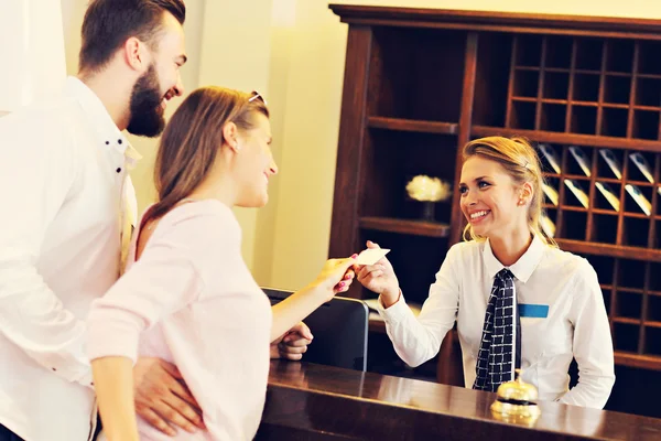 Par och receptionist på räknaren i hotel — Stockfoto