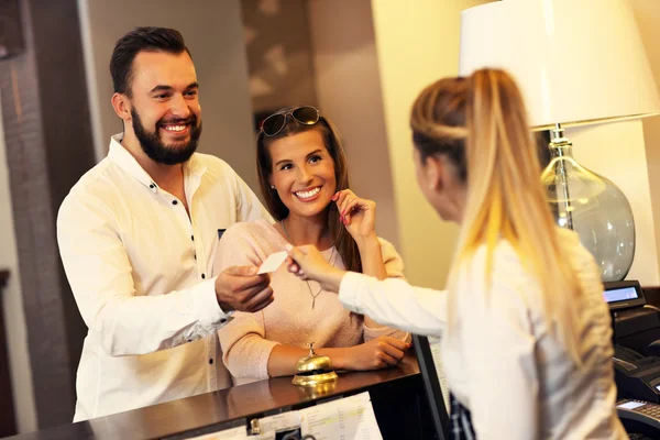 Casal e recepcionista no balcão — Fotografia de Stock