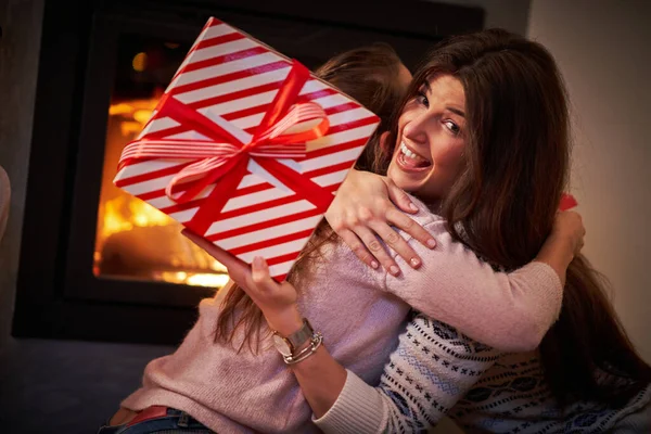 Chicas amigas intercambiando regalos de Navidad sobre la chimenea —  Fotos de Stock