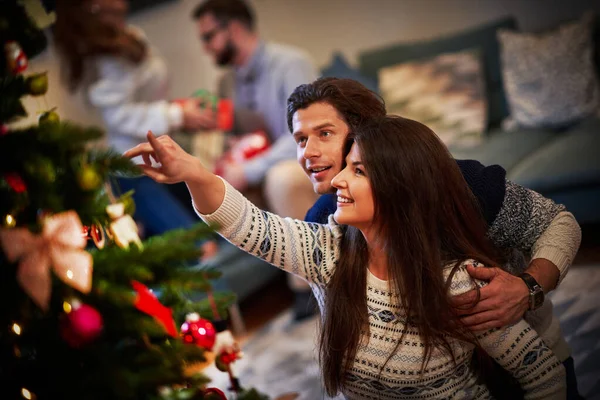Parejas adultas divirtiéndose sobre árbol de Navidad —  Fotos de Stock