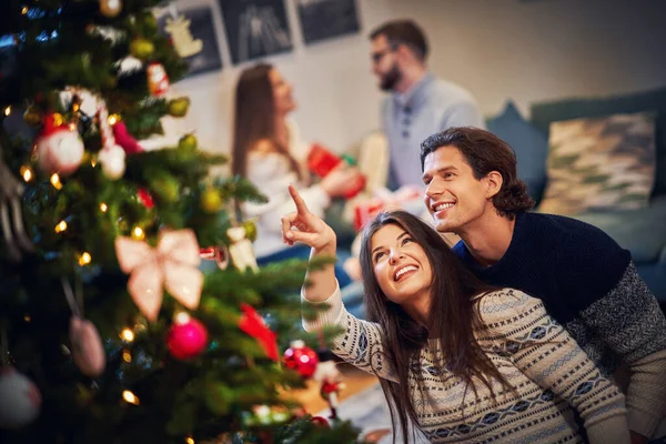 Volwassen stellen die plezier hebben boven de kerstboom — Stockfoto