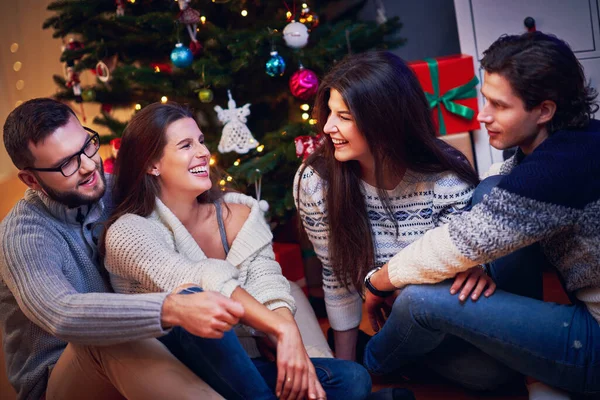 Grupo de amigos con regalos celebrando la Navidad en casa —  Fotos de Stock