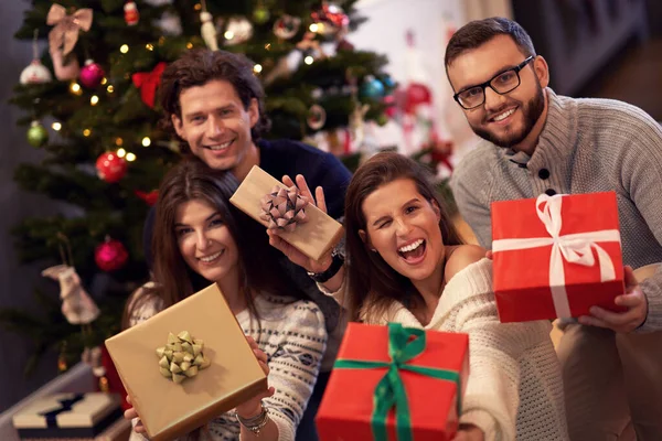 Gruppo di amici con regali per festeggiare il Natale a casa — Foto Stock