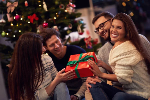 Grupo de amigos com presentes celebrando o Natal em casa — Fotografia de Stock