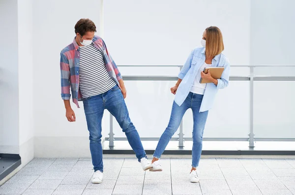 Studenten tragen Masken, während sie auf dem Campus Hallo sagen — Stockfoto